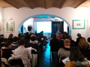 a crowd of people sitting in a room with a screen at Campastrello Sport Hotel Residence in Castagneto Carducci