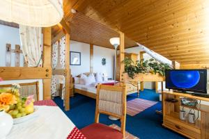 een woonkamer met een bed en een tv in een kamer bij Ferienwohnungen Salmen in Pörtschach am Wörthersee