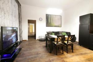 Lana Appartements في فيينا: غرفة معيشة مع طاولة طعام وتلفزيون