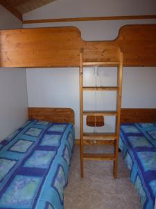 um quarto com 2 beliches e uma escada em Camping Fraiteux em Plombières-les-Bains