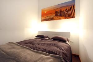 een bed in een slaapkamer met een schilderij aan de muur bij Lana Appartements in Wenen