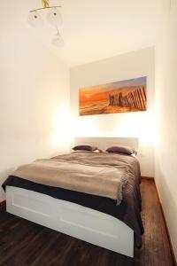 een slaapkamer met een bed met een schilderij aan de muur bij Lana Appartements in Wenen