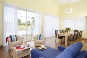 - un salon avec un canapé bleu et une table dans l'établissement Résidence Prestige Odalys Les Greens du Bassin, à Gujan-Mestras