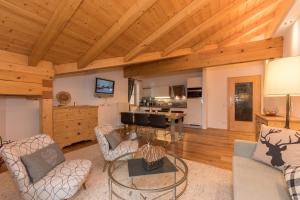 ein Wohnzimmer mit Holzdecken und eine Küche in der Unterkunft Appartements-Pension Renberg in Maria Alm am Steinernen Meer