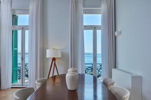 a dining room with a table and views of the ocean at Poseidonion Grand Hotel in Spetses