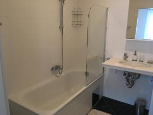 ein Badezimmer mit einer Dusche, einer Badewanne und einem Waschbecken in der Unterkunft New Stylish Apartment in Wien