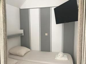 Kleines Zimmer mit einem Bett und einem TV in der Unterkunft Hotel Valkenhof in Zoutelande