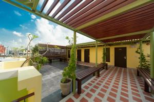 a patio with a wooden pergola and a bench at Tara Place Hotel Bangkok in Bangkok