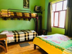 a bedroom with two bunk beds and a window at Hostal Princesa Maria in Baños