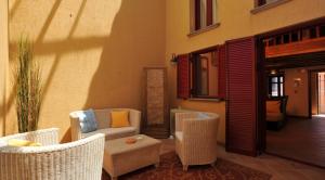 a patio with chairs and a couch and a table at The Varos Residences Hotel in Város