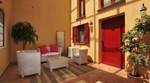 a patio with a red door and chairs and a table at The Varos Residences Hotel in Város