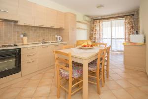 a kitchen with a table with a bowl of fruit on it at Zanella Gedici in Gedići