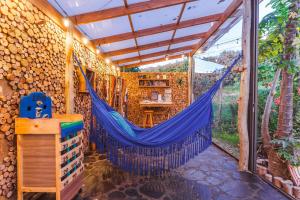 a hammock in a room with a wall of logs at Casa Agrreste in Sopó