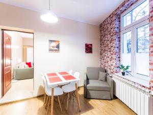 a living room with a table and a chair at TatryTop Studio Krupówki in Zakopane