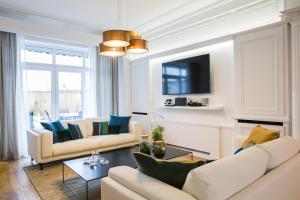 - un salon avec deux canapés et une télévision dans l'établissement Luxueux logement Bourgeois de 250 M2 climatisé, à Lille