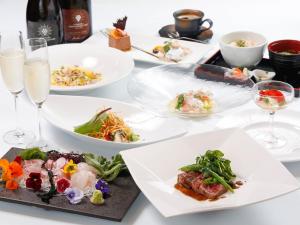 una tavola con piatti di cibo e bicchieri di vino di Auberge Yuraku a Yugawara