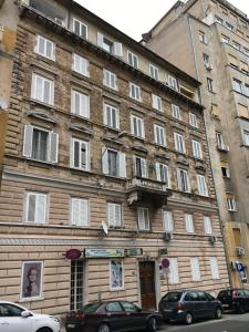 a large brick building with cars parked in front of it at Flumen in Rijeka