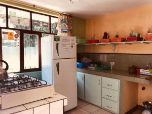 a kitchen with a refrigerator and a stove at Hostal Princesa Maria in Baños