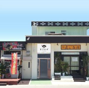 un bâtiment avec un panneau à l'avant dans l'établissement Matsukaze The Guest House Ishigaki, à Ishigaki