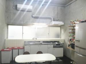 una pequeña cocina con fregadero y nevera. en Matsukaze The Guest House Ishigaki en Isla Ishigaki