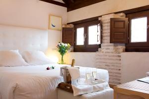 a bedroom with a white bed and a vase of flowers at Gar Anat Hotel Boutique in Granada