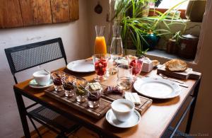 una mesa de madera con platos y vasos. en Piazza San Pantaleo, en Sorso