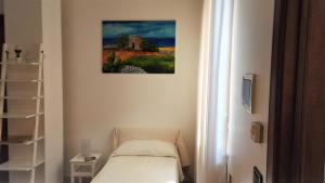 Cette chambre dispose d'un lit et d'une peinture murale. dans l'établissement Antico Camino B&B, à Muro Leccese