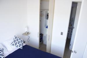 a small bedroom with a bed and a mirror at Serena frente al Mar in Coquimbo