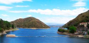 a view of a river with mountains in the background at Hotel Playa in Villa Carlos Paz