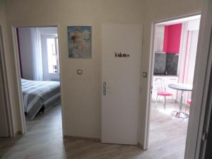 una camera con un letto e una porta con i servizi igienici di parola di Katarina a Vittel