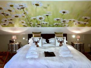 Una cama blanca con toallas y flores. en Ashbrook House B&B, en Aughnacloy