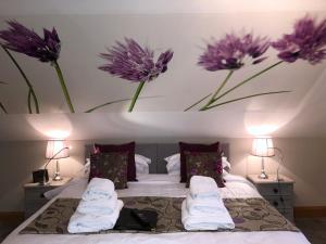 1 dormitorio con 1 cama con flores púrpuras en la pared en Ashbrook House B&B en Aughnacloy