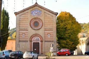 une église avec des voitures garées devant elle dans l'établissement B&B Percorso Verde, à Ponte Valleceppi