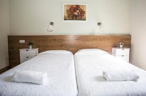 two beds in a bedroom with white sheets and pillows at Mai & Maud Paralel Apartment in Barcelona