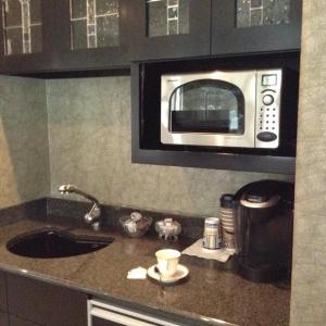 a kitchen counter with a microwave above a sink at Mill Creek Gardens in Winamac +33 photos