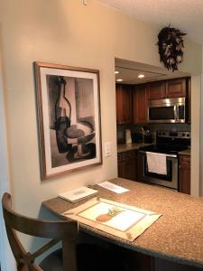 a kitchen with a table with a picture on the wall at Crescent Arms 105N in Sarasota