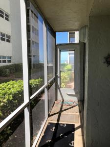 an empty hallway with an open door to a balcony at Crescent Arms 105N in Sarasota