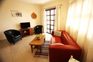 ein Wohnzimmer mit einem roten Sofa und einem Tisch in der Unterkunft Sea View Apartments in Pissouri