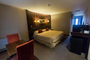 a hotel room with a bed and a table at Imago Hotel & Spa in El Calafate