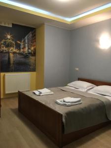 a bedroom with a large bed with towels on it at Апартаменти готельного типу in Lviv