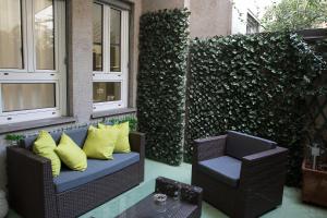 a patio with two chairs and a couch with yellow pillows at Milano Porta Venezia Suite Centro in Milan