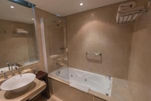 a bathroom with a tub, toilet and sink at Imago Hotel & Spa in El Calafate