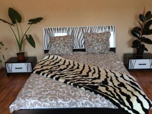 Cama con manta de cebra y almohadas en Апартаменты, en Izmaíl