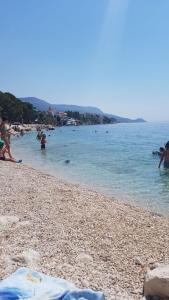 a group of people playing in the water on a beach at Apartmani Antonia Nakić -Stobreč in Split