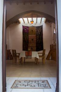 a dining room with a table and chairs and a rug at Neroli House in Archangelos