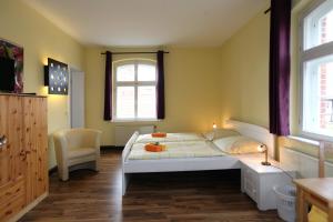 1 dormitorio con 1 cama y 1 silla en Alte Schule Schnackenburg en Schnackenburg
