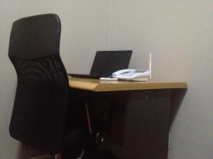a desk with a black chair and a laptop computer at Angel Guest House in Maputo