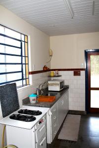 a kitchen with a sink and a stove top oven at Quinta dos Paiva: horta natural e sossego in Monte Alegre do Sul