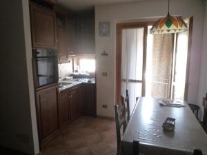 a dining room with a table and a kitchen at Casa Corone in Alfedena