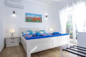 uma cama branca num quarto com uma janela em Villa Dino em Lukoran